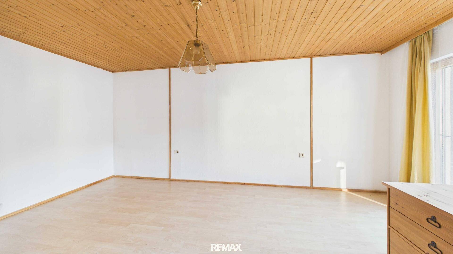 Helles Schlafzimmer mit Holzdecke und Holzboden, bereit zur individuellen Gestaltung.