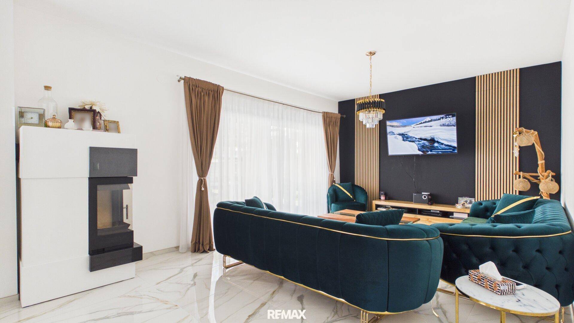 Gemütliches Wohnzimmer mit modernem Kaminofen, dunklen Sofas und stilvoller Wandgestaltung.