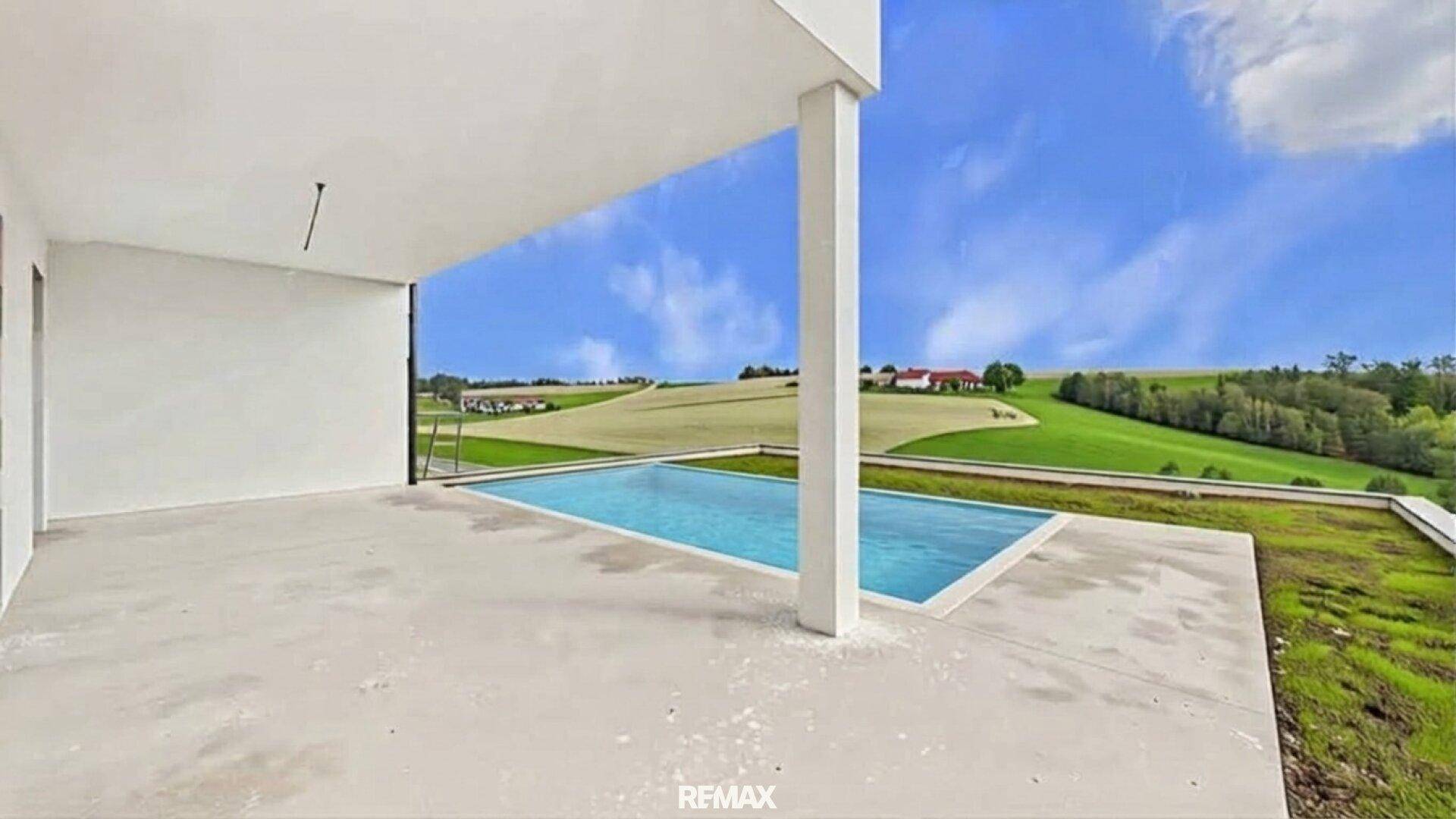 Moderne Terrasse mit Pool und Panoramablick auf die umliegende Hügellandschaft.