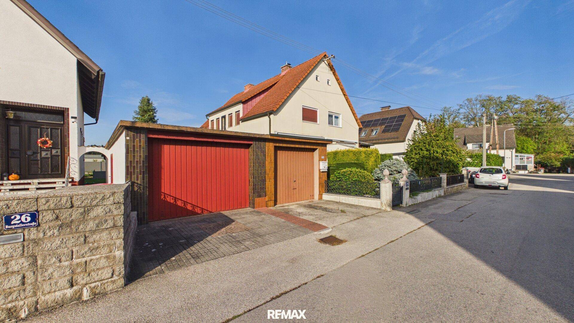 Ansicht des Hauses mit zwei Garagen und der Zufahrt von der ruhigen Wohnstraße.