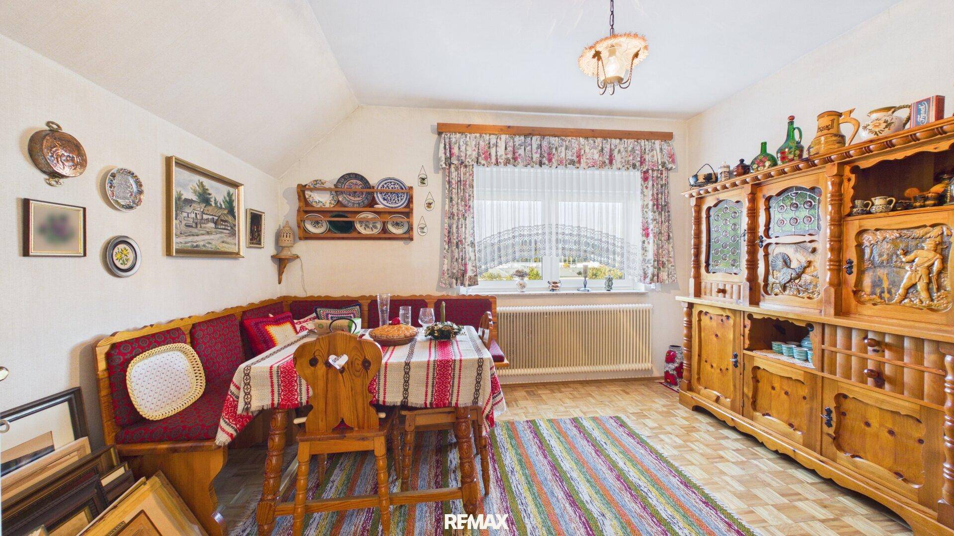 Esszimmer im Dachgeschoss mit Holzeinrichtung, Eckbank und traditioneller Dekoration.