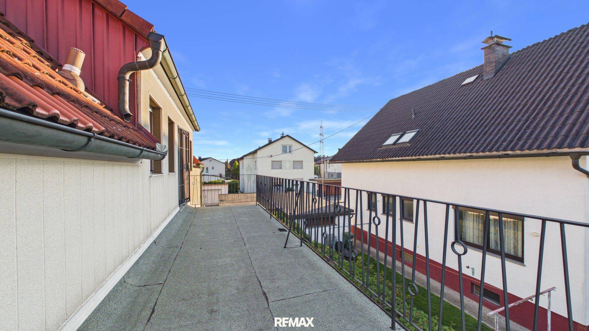 Große Dachterrasse mit Metallgeländer und weitem Blick über die Nachbarschaft.
