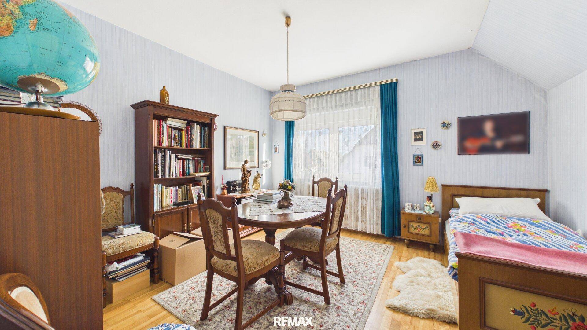 Schlafzimmer mit Einzelbett, Bücherregal und Schreibtisch, ideal als Kinder- oder Gästezimmer.
