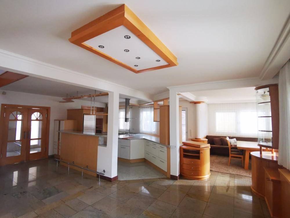 Offene Küche mit Holzdetails und integriertem Essbereich, ideal für geselliges Beisammensein.