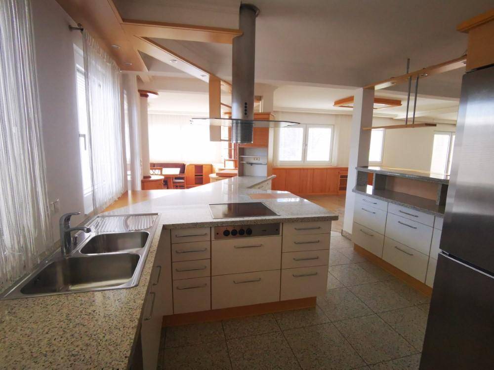 Funktionale Küche mit Granitarbeitsplatten, Kochinsel und modernen Einbaugeräten.
