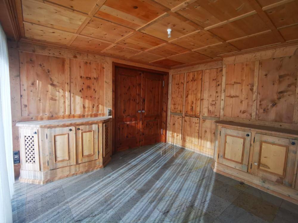 Geräumiges Zimmer mit traditioneller Holztäfelung, Kassettendecke und Steinboden, gut erhalten.