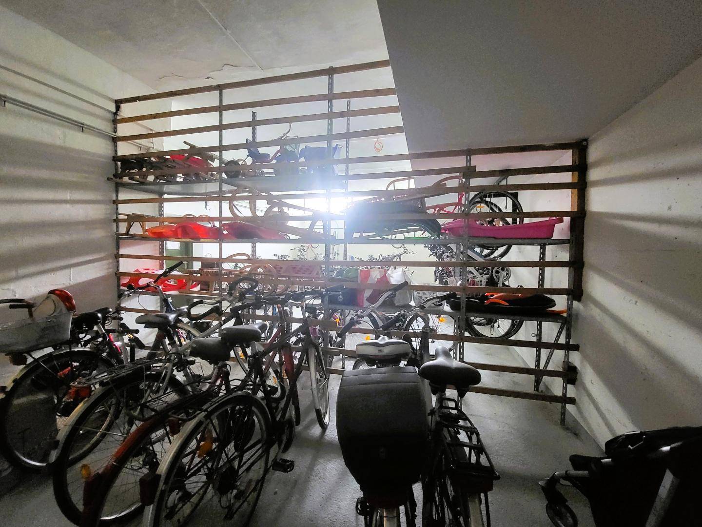 Fahrradabstellraum im Untergeschoss mit vielen Fahrrädern und praktischen Regalsystemen.