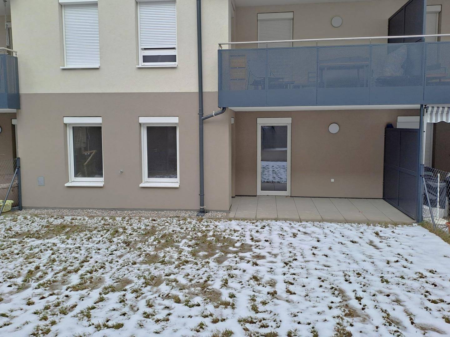 Erdgeschoss-Terrasse mit Zugang zum Gartenbereich, teilweise mit Schnee bedeckt.