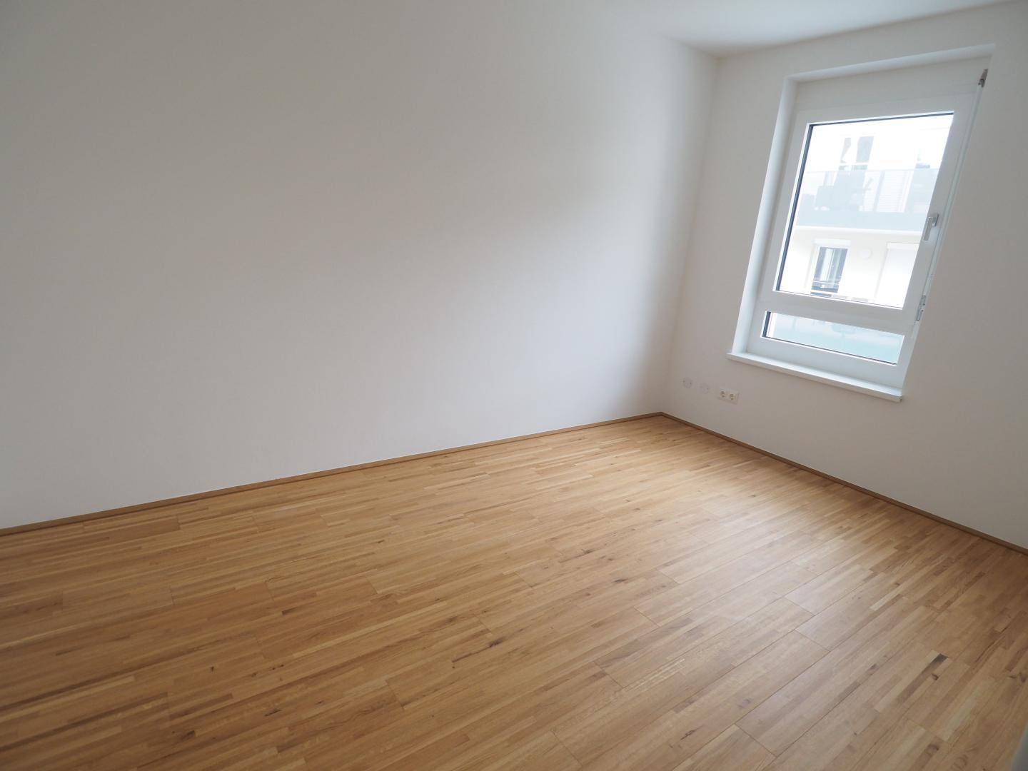 Geräumiges Zimmer mit Parkettboden und schrägem Fenster, vielseitig nutzbar.