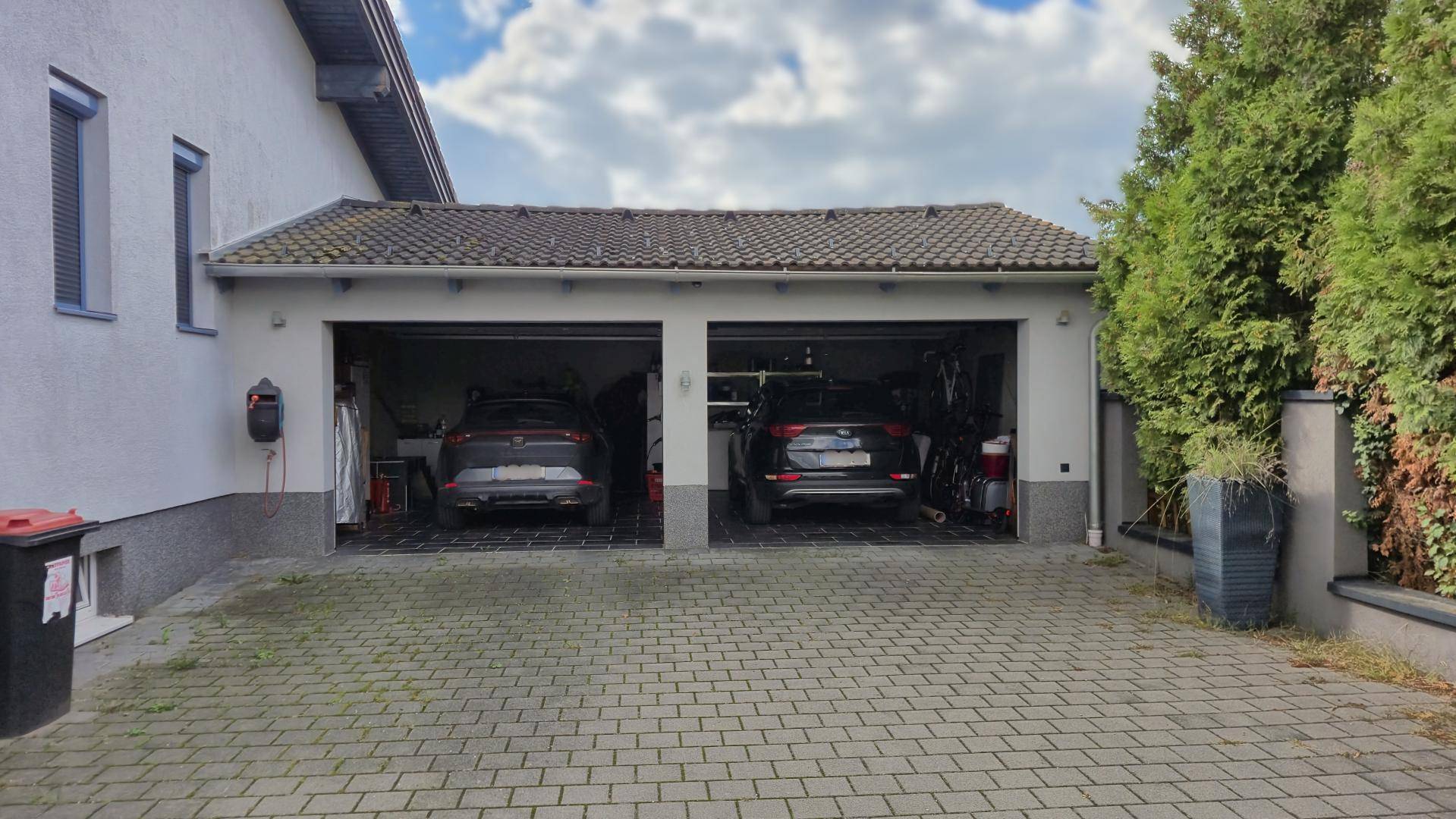Doppelgarage mit zwei Stellplätzen und gepflasterter Zufahrt.