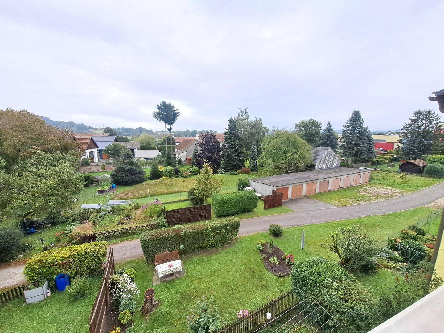 Weitläufiger Blick über Gärten, Bäume und Garagen in einer ruhigen Wohngegend.