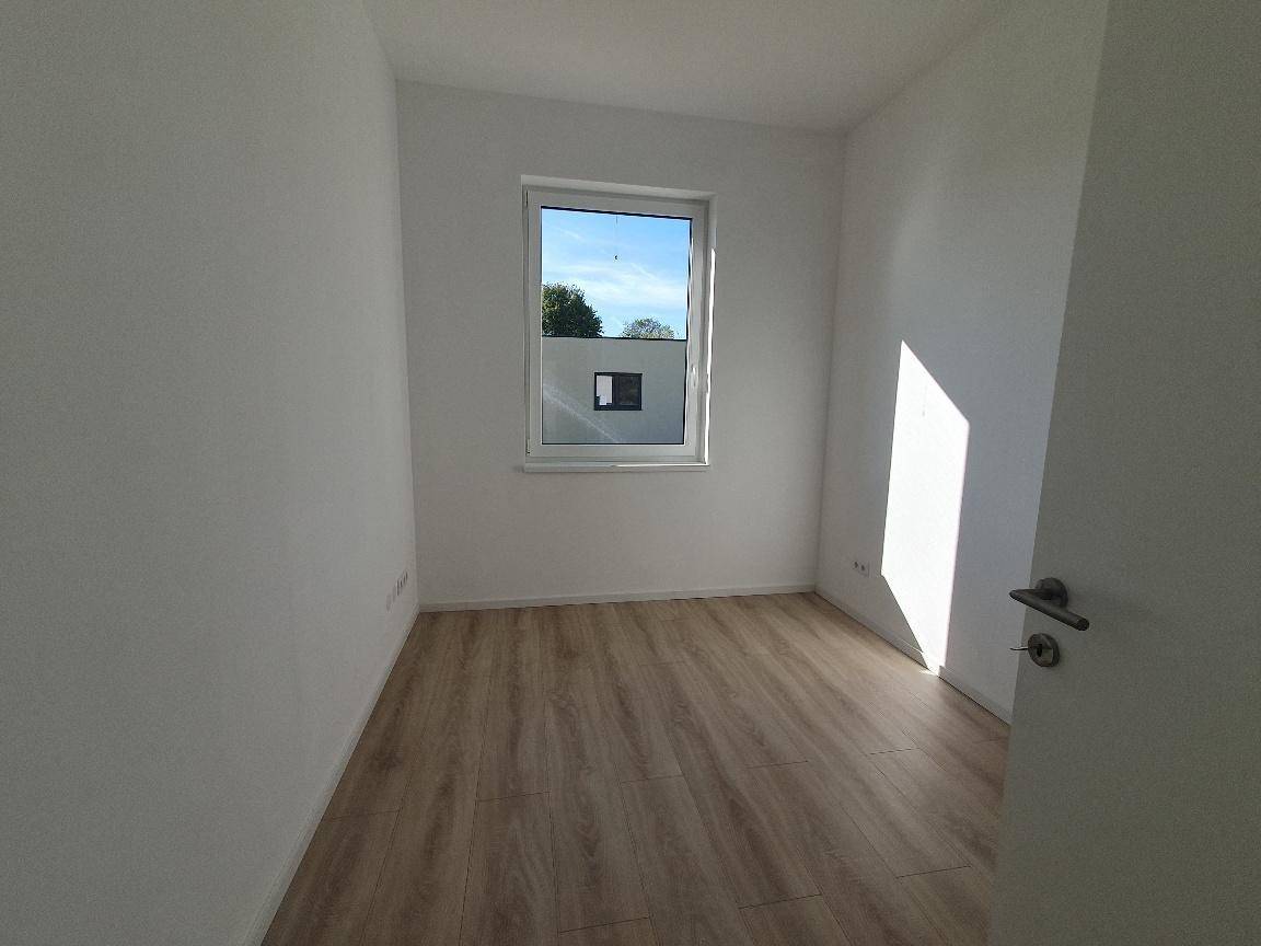 Heller, unmöblierter Raum mit Laminatboden und einem Fenster, ideal als Schlaf- oder Arbeitszimmer.
