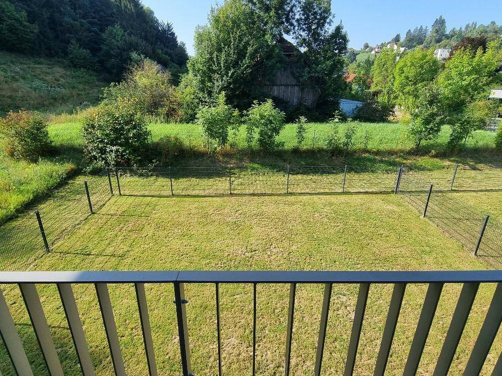 Weitläufiger Blick über die grüne Rasenfläche und die umliegende Naturlandschaft.