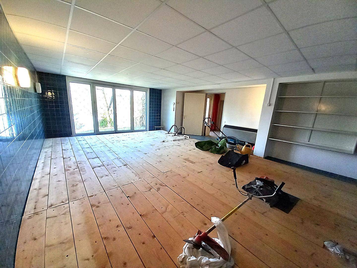 Geräumiger Innenpoolbereich mit großen Glastüren zum Außenbereich, derzeit in Renovierung.