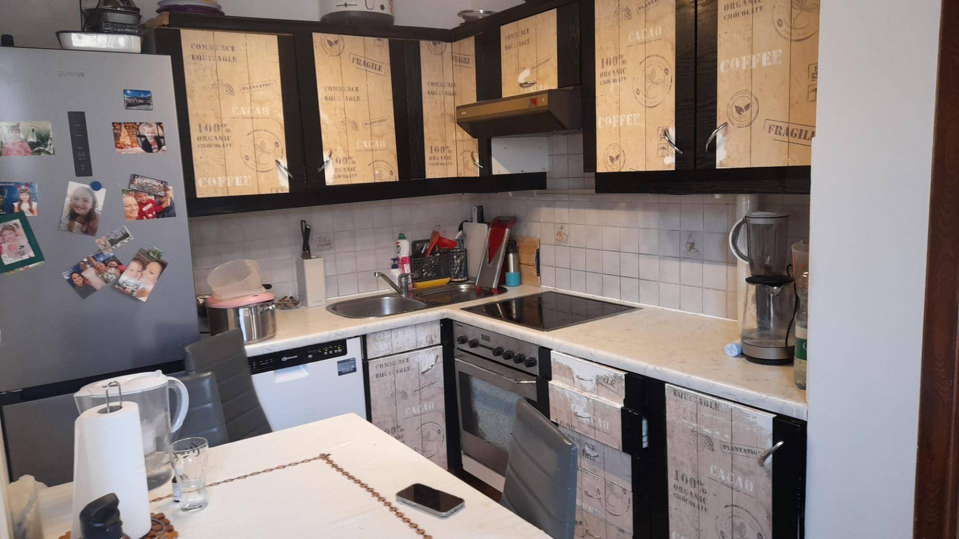 Detailansicht der Küche mit Einbaugeräten, Spüle und individuell gestalteten Schrankfronten.