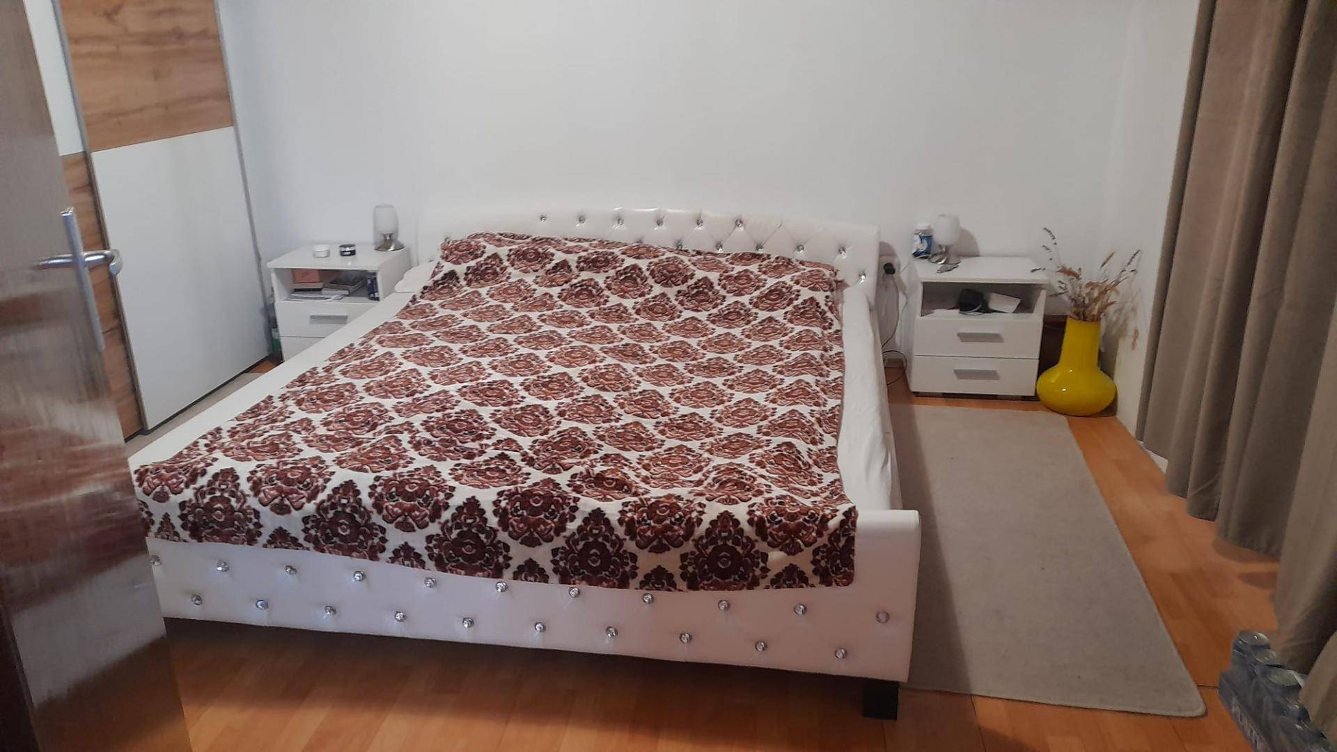 Schlafzimmer mit großem Doppelbett, zwei Nachttischen und einem Kleiderschrank.
