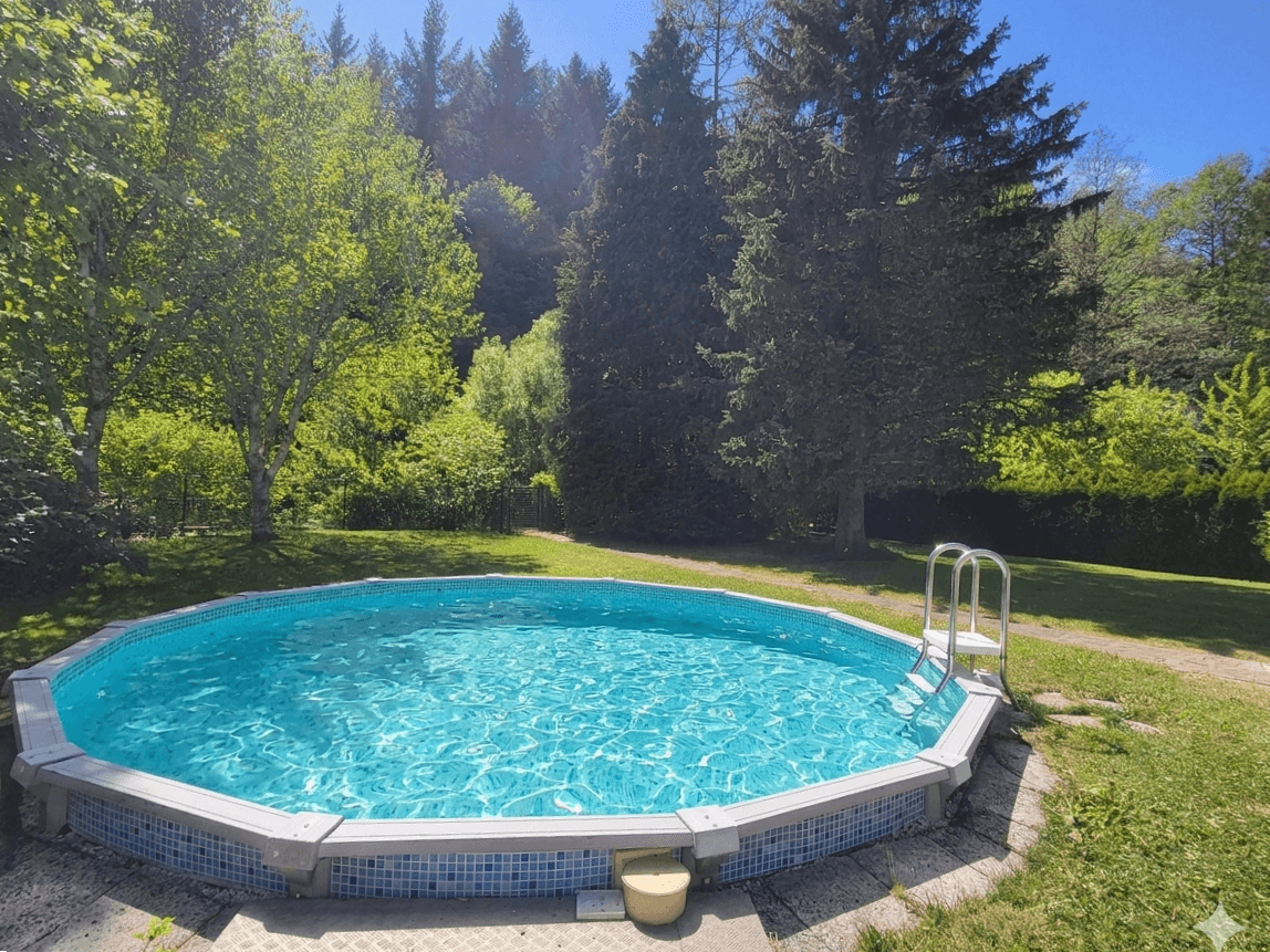Runder Aufstellpool im sonnigen Garten, umgeben von Rasen und hohen Bäumen.