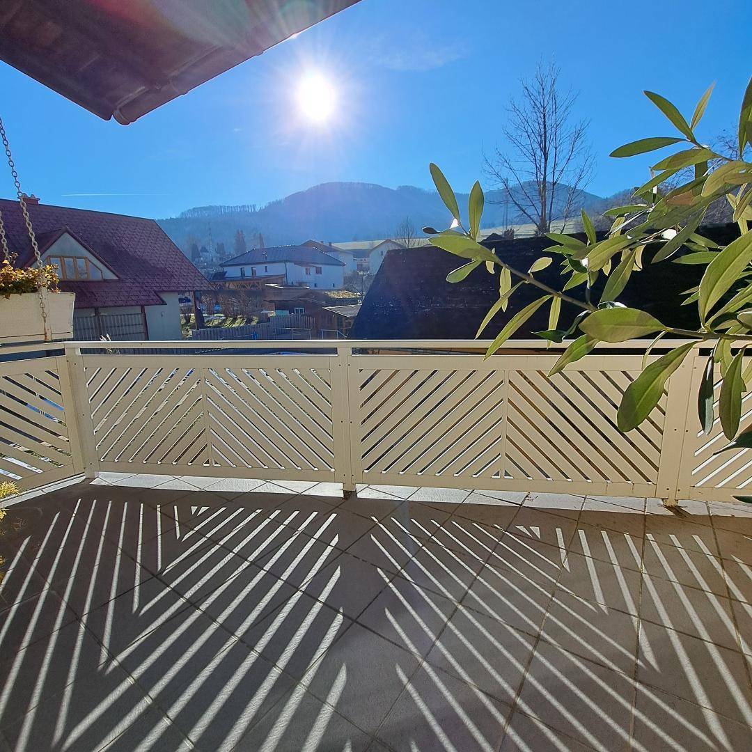 Sonniger Balkon mit Bergblick und moderner Brüstung, ideal zum Entspannen im Freien.