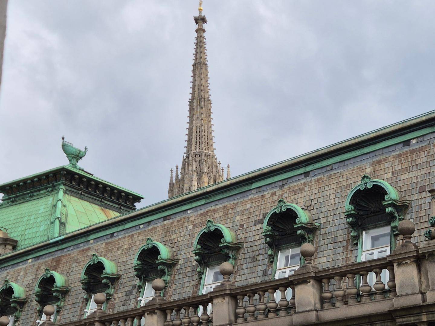 Historisches Gebäude mit patiniertem Kupferdach und Blick auf den Stephansdom.