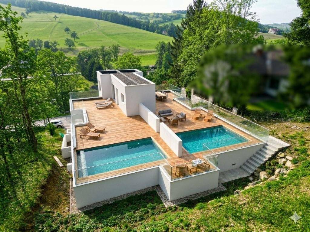 Luxuriöse Außenanlage mit zwei Pools, Holzterrassen und Sitzbereichen, umgeben von grüner Natur.