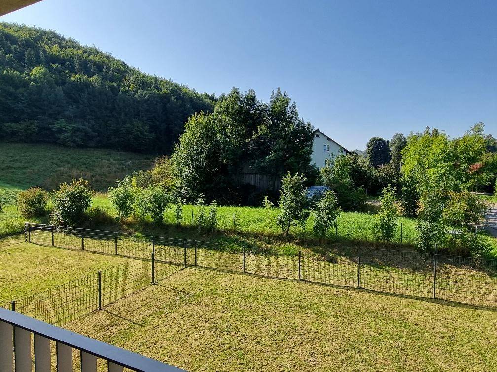 Weitläufiger Blick vom Balkon auf die grüne Hügellandschaft und die Umgebung.