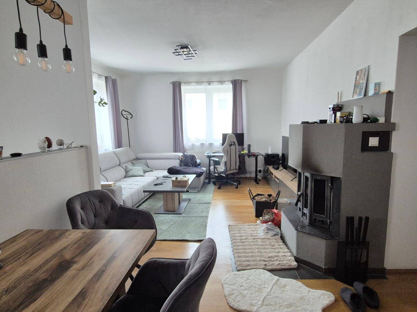 Gemütlicher Wohn-Essbereich mit Kamin, bequemer Couch und Holzboden.