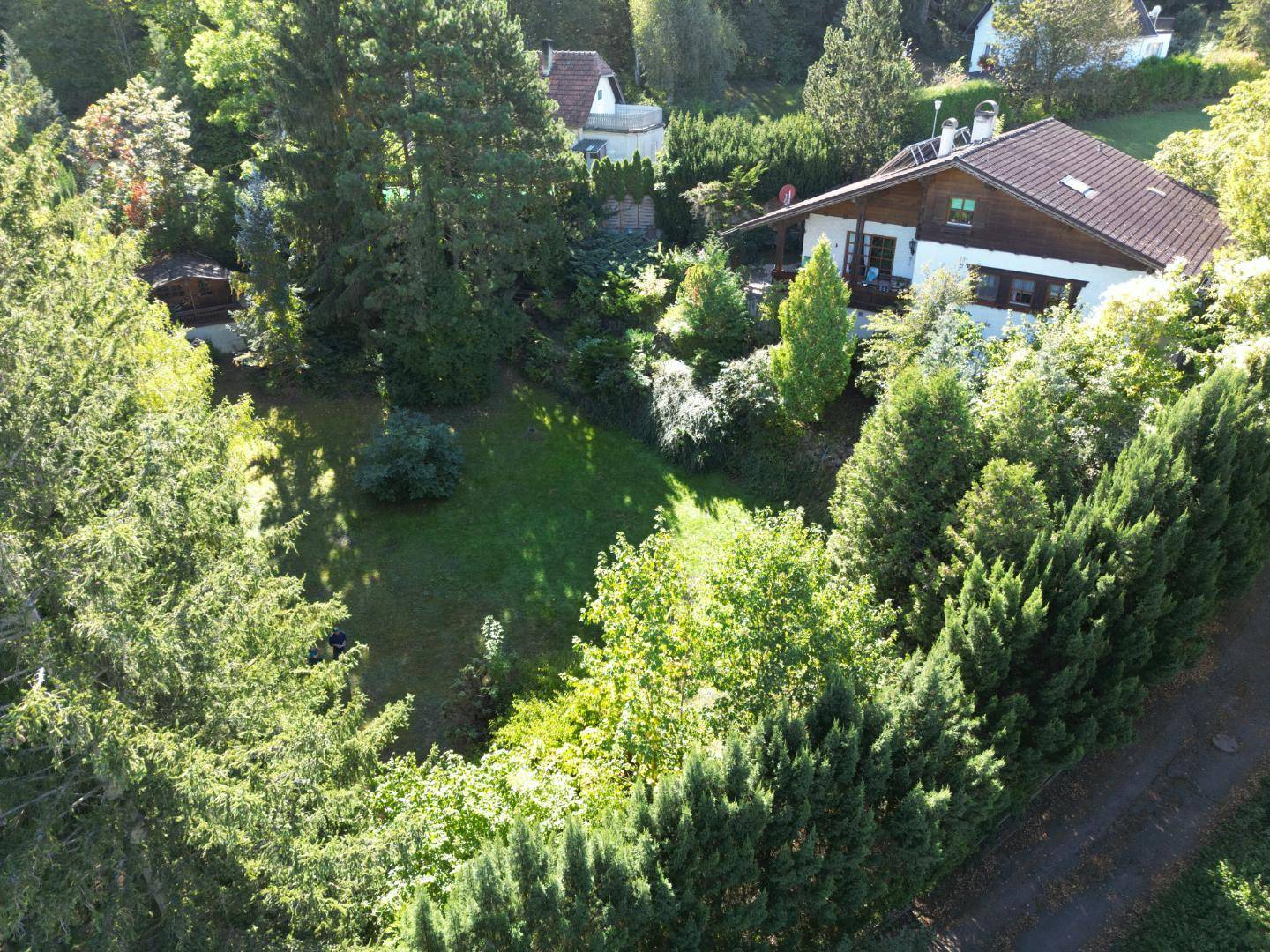 Luftaufnahme des Anwesens mit großem Garten und charmantem Wohnhaus, umgeben von Natur.