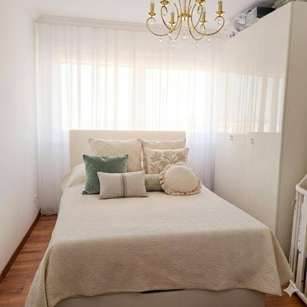 Gemütliches Schlafzimmer mit Doppelbett, vielen Kissen und großen Fenstern für viel Helligkeit.