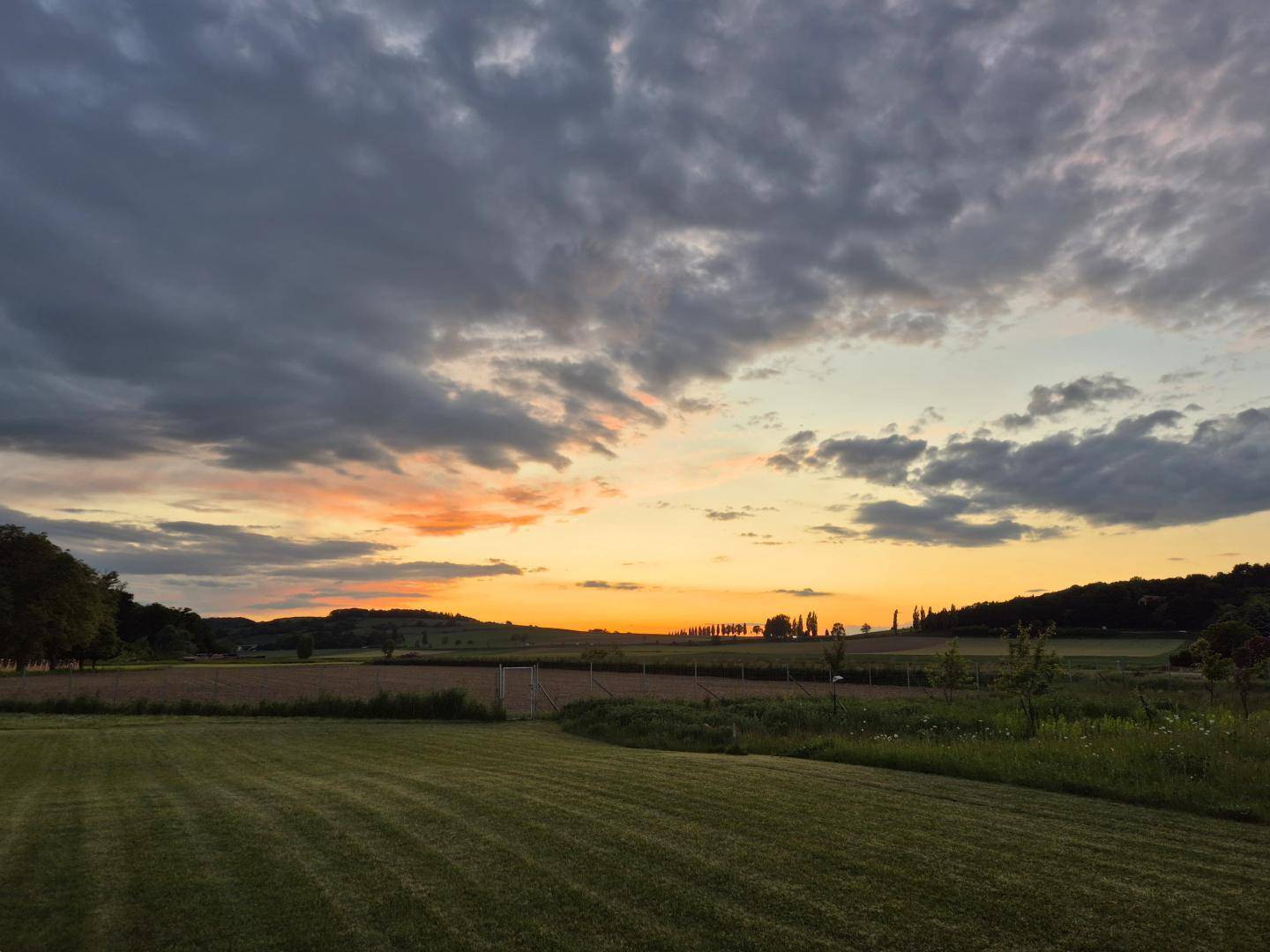 Malerischer Sonnenuntergang über den Feldern mit weitem Blick in die Landschaft.