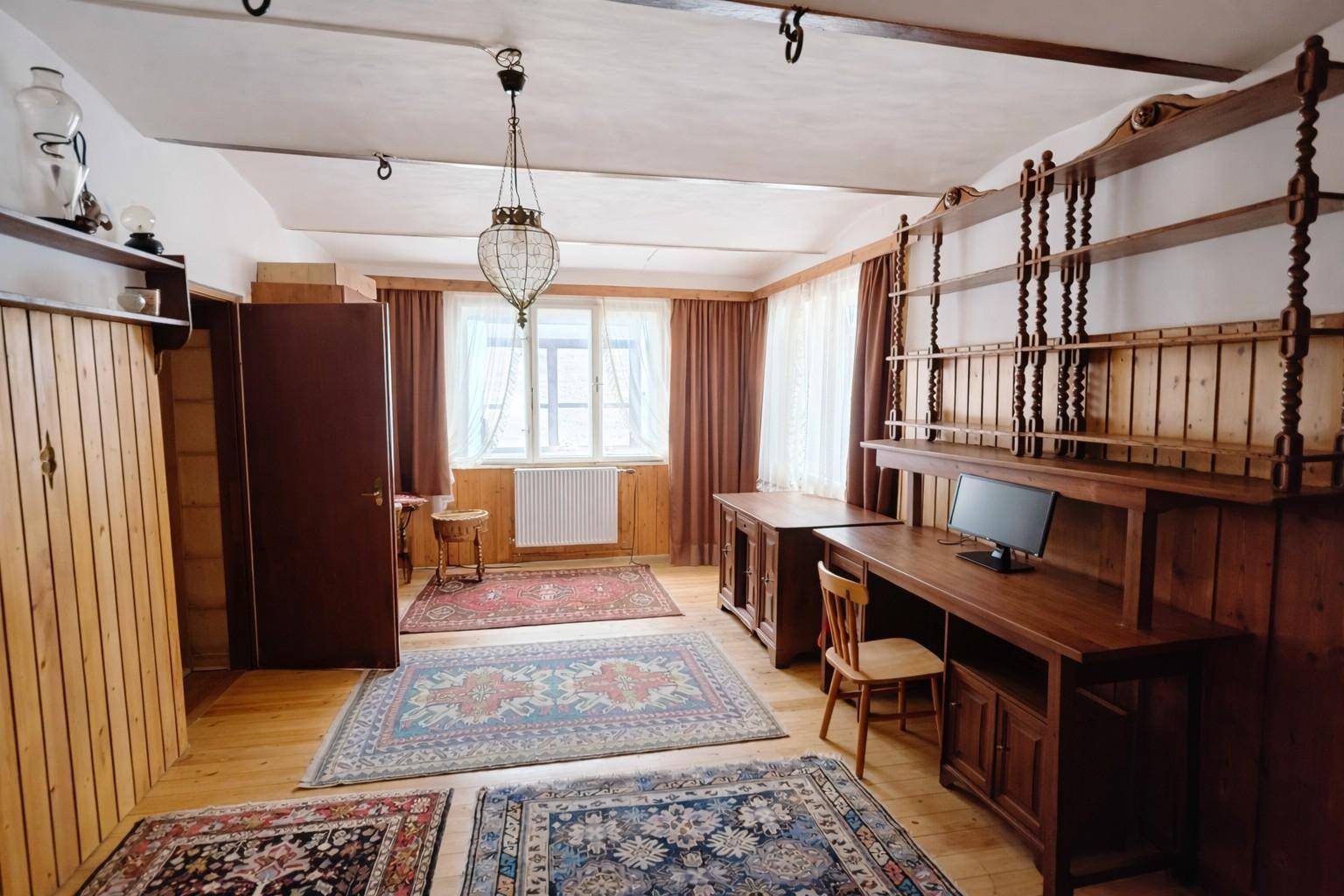 Geräumiges Arbeitszimmer mit Holzdecke, großen Fenstern und traditionellen Holzregalen.