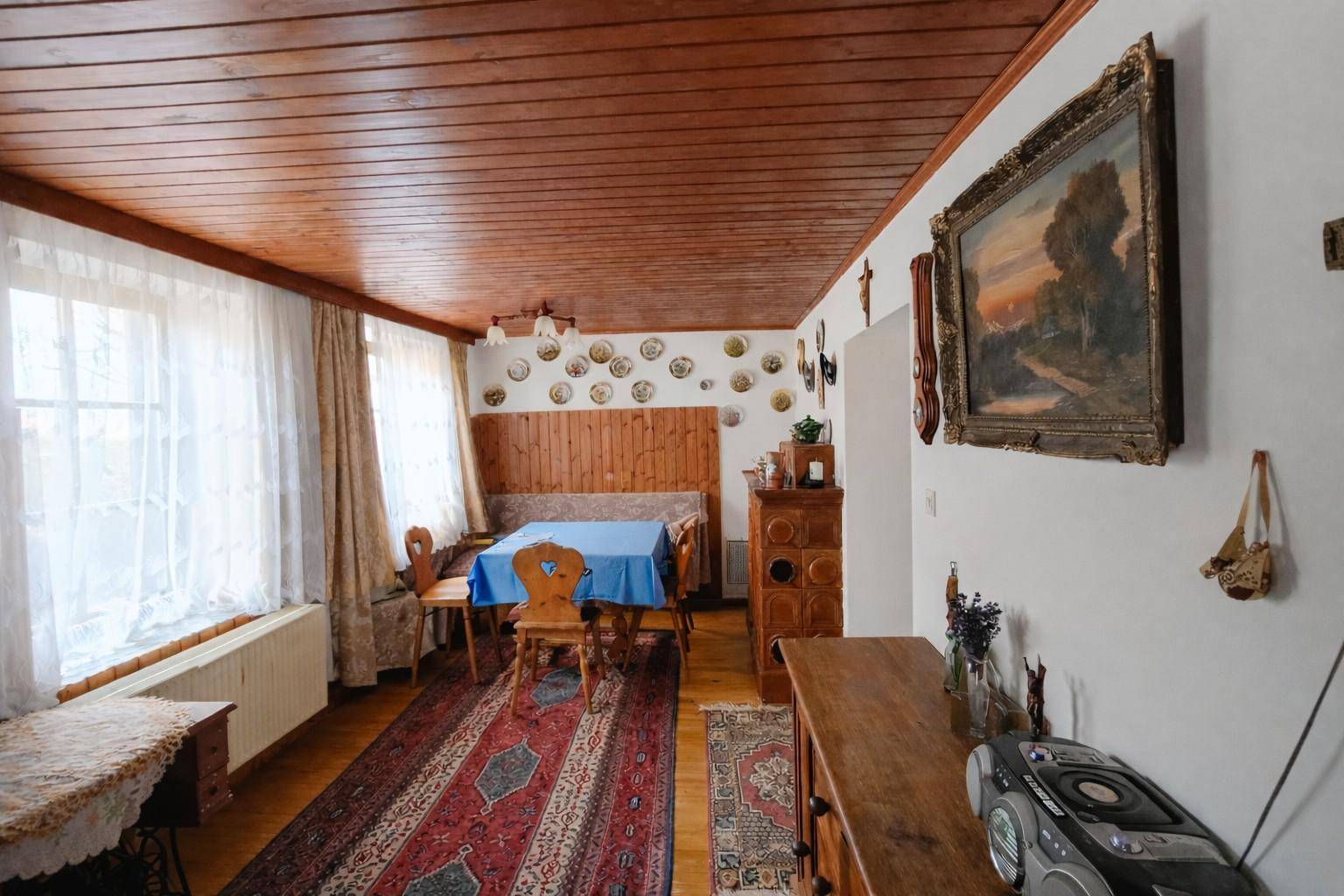 Esszimmer im Landhausstil mit Holzdecke, traditionellen Möbeln und dekorativen Tellern an der Wand.