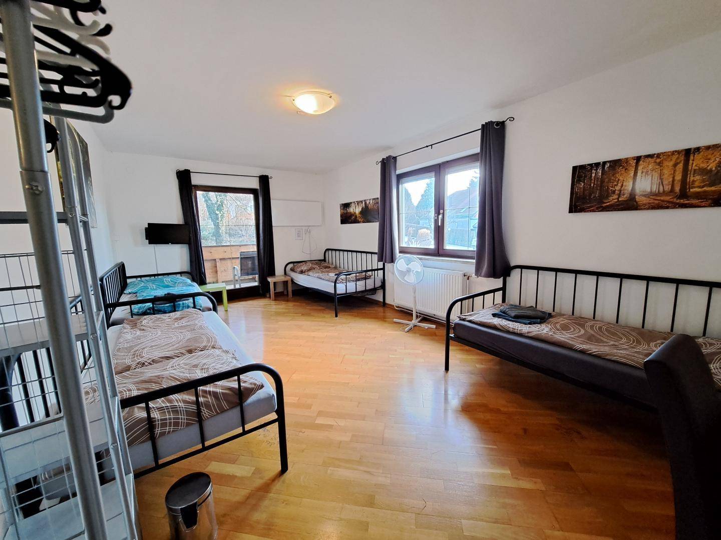 Helles und geräumiges Schlafzimmer mit mehreren Betten und Sofa, bietet viel Platz.