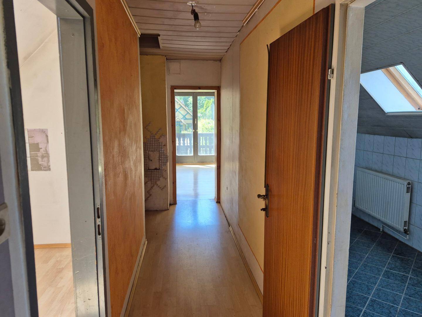 Flur im Obergeschoss mit Holzboden und Zugang zu verschiedenen Räumen.