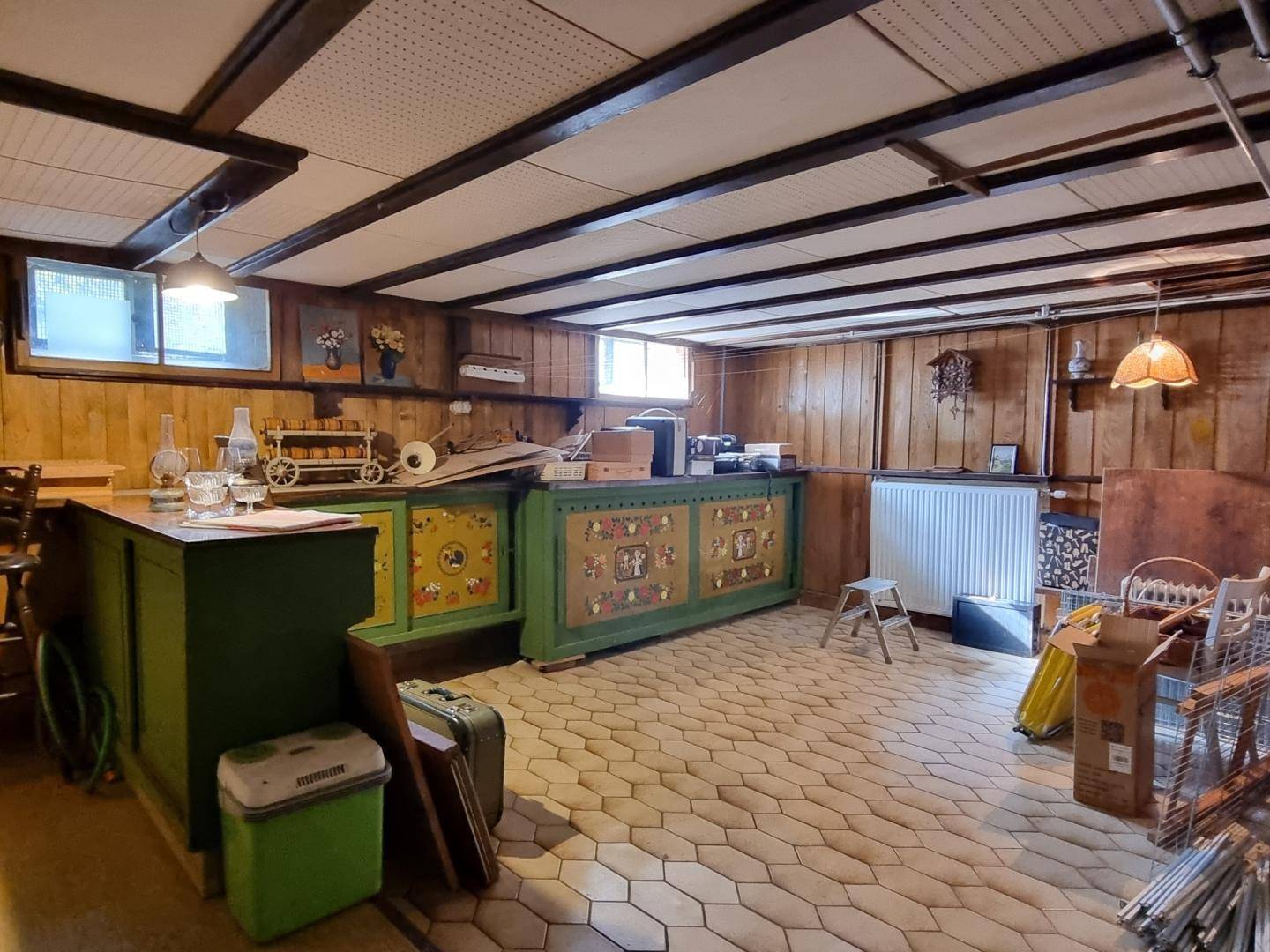 Geräumiger Kellerraum mit Holzwänden, Fliesenboden und verschiedenen Lagerbereichen.