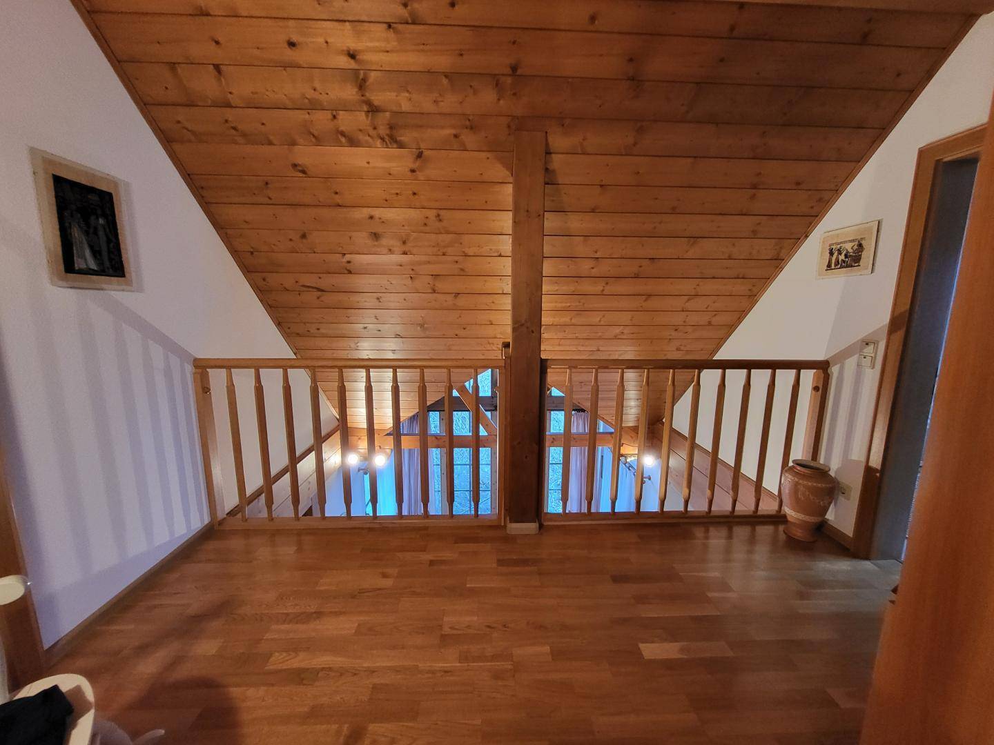 Offener Galeriebereich im Obergeschoss mit Holzgeländer und Holzboden.