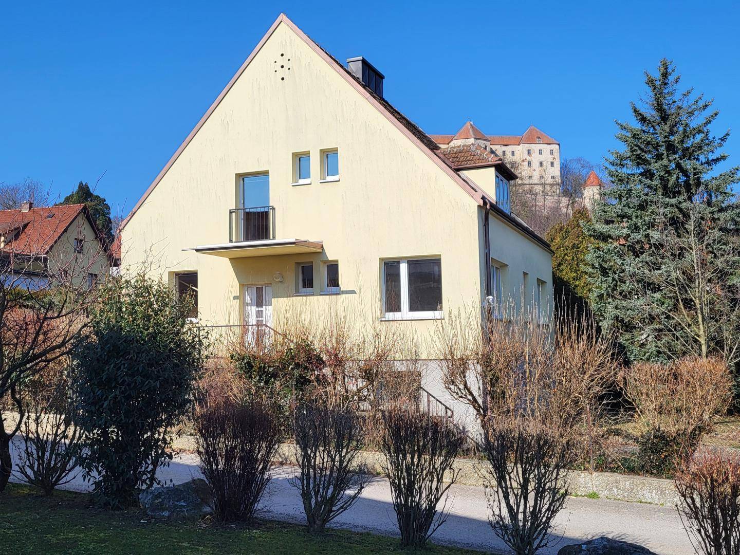 Vorderansicht des Hauses mit kleinem Balkon und Blick auf die Burg.
