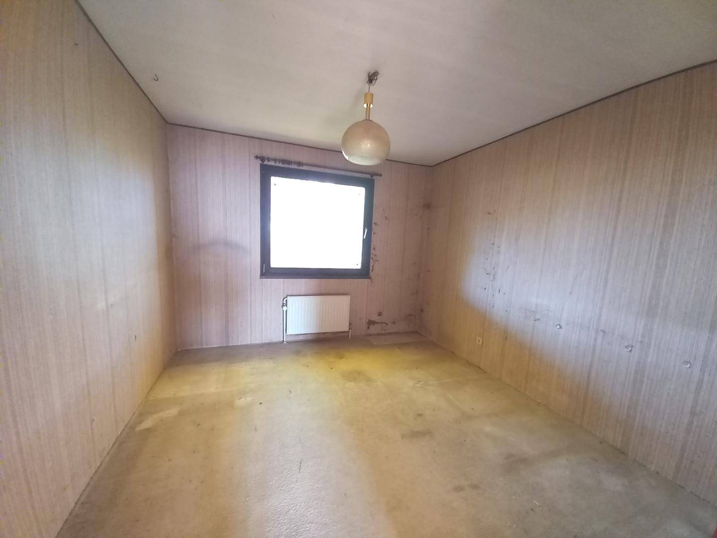 Unmöblierter Raum mit Tapeten und Fenster, ideal für Schlafzimmer oder Büro.