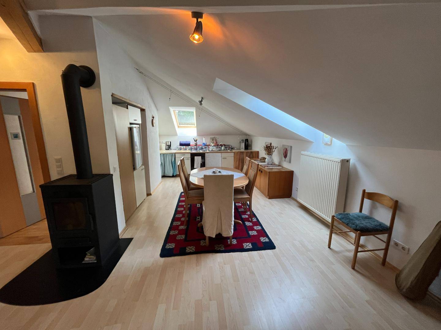 Dachgeschosswohnung mit offener Küche, Essbereich und Holzofen.