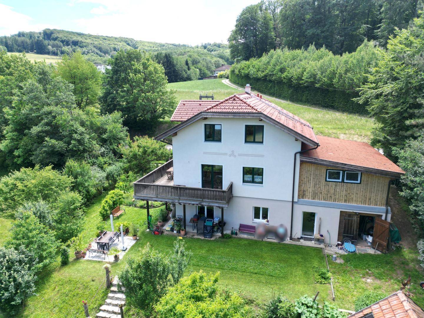 Großzügiger Gartenbereich mit Terrasse und Blick auf die umliegende Landschaft.
