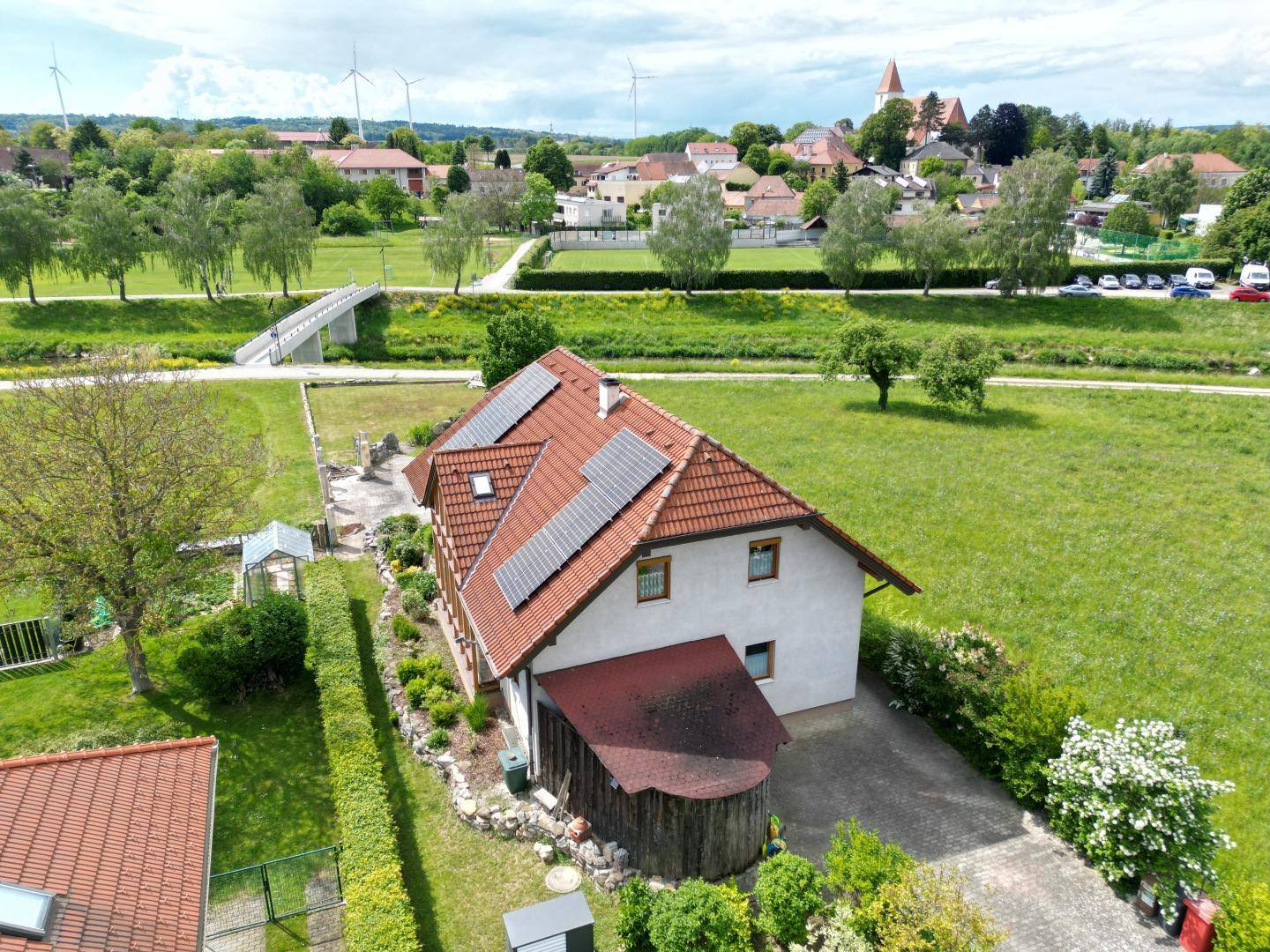 Luftaufnahme des Hauses mit Solaranlage auf dem Dach und grüner Umgebung.