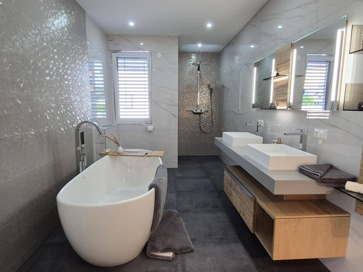 Geräumiges Badezimmer mit freistehender Badewanne, großer Dusche und Doppelwaschbecken.