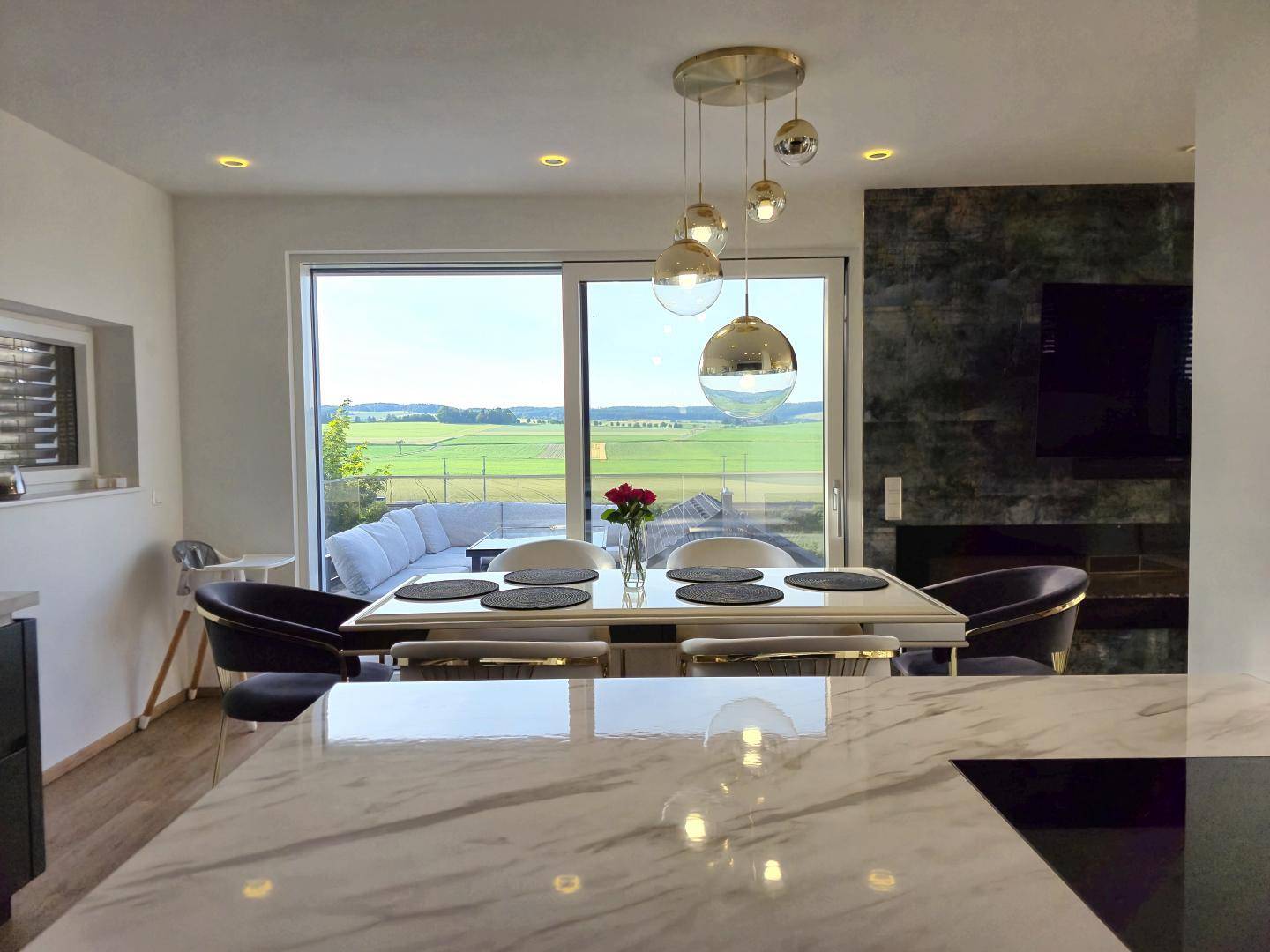 Heller Essbereich mit modernem Design, Blick auf die Terrasse und die weite Landschaft.