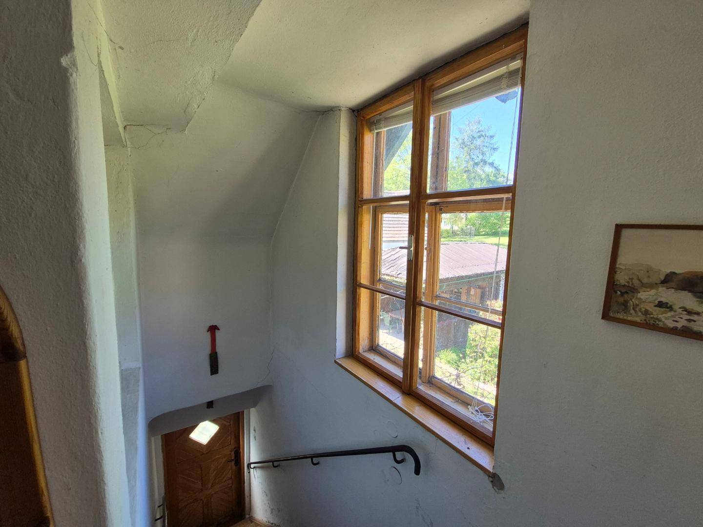 Treppenhaus mit Holzfenstern und Blick ins Grüne, das die verschiedenen Etagen verbindet.