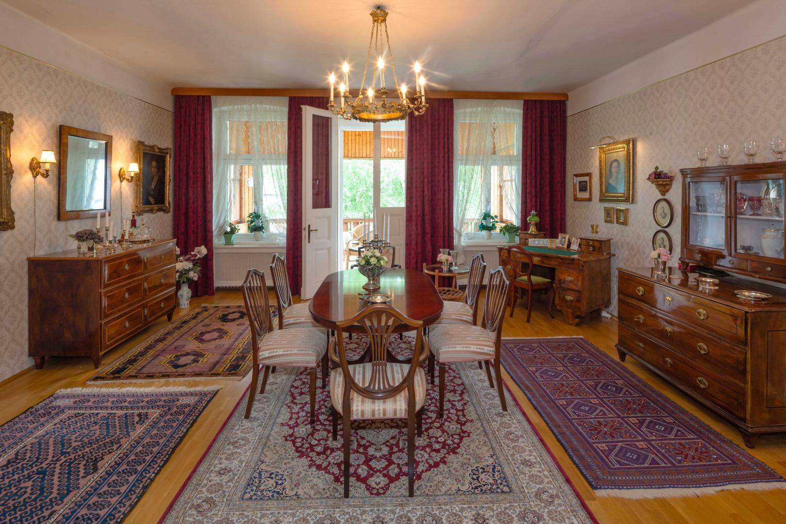 Elegantes Esszimmer mit klassischem Holztisch, passenden Stühlen und Zugang zu einem Balkon.