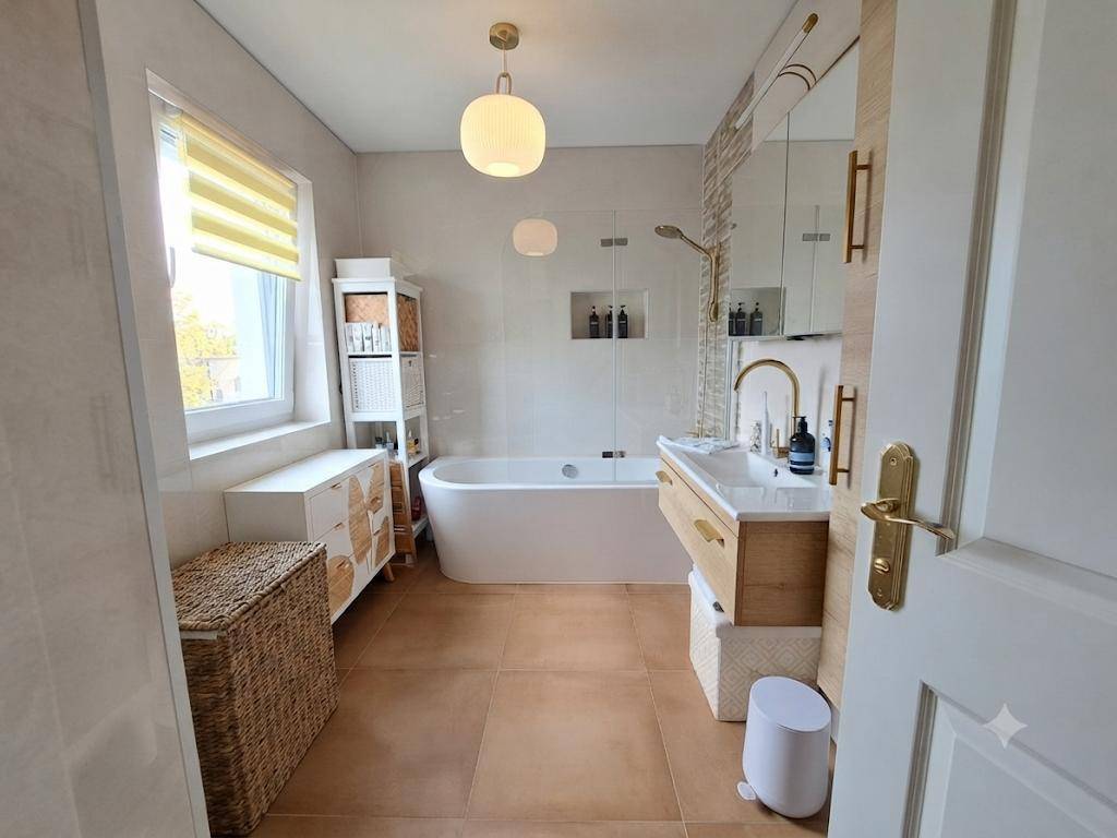Modernes Badezimmer mit freistehender Badewanne, Einzelwaschbecken und einem Fenster für Tageslicht.
