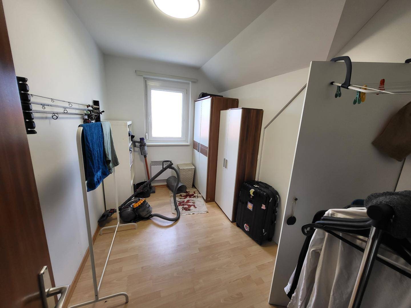 Praktischer Abstellraum im Dachgeschoss mit Fenster und vielseitigen Stauraummöglichkeiten.