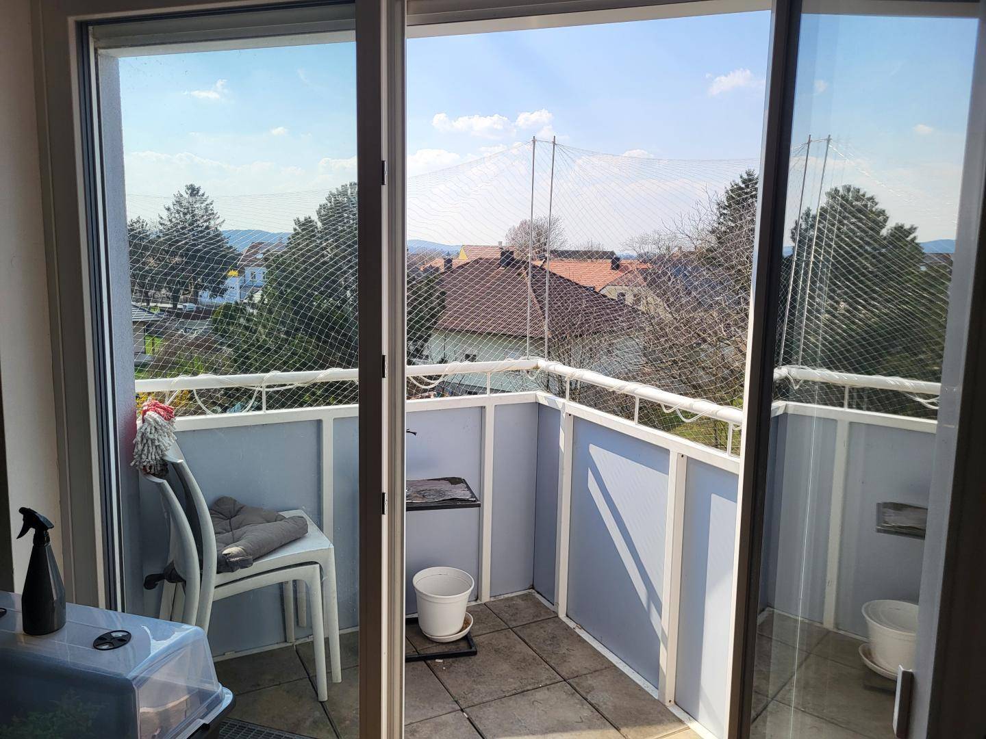 Kleiner Balkon mit Fliesenboden und weitem Blick über die umliegende Landschaft.