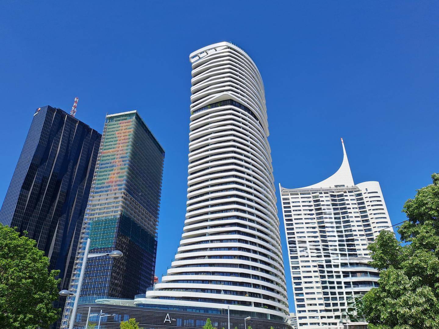 Beeindruckende moderne Hochhäuser mit einzigartiger Architektur unter blauem Himmel.
