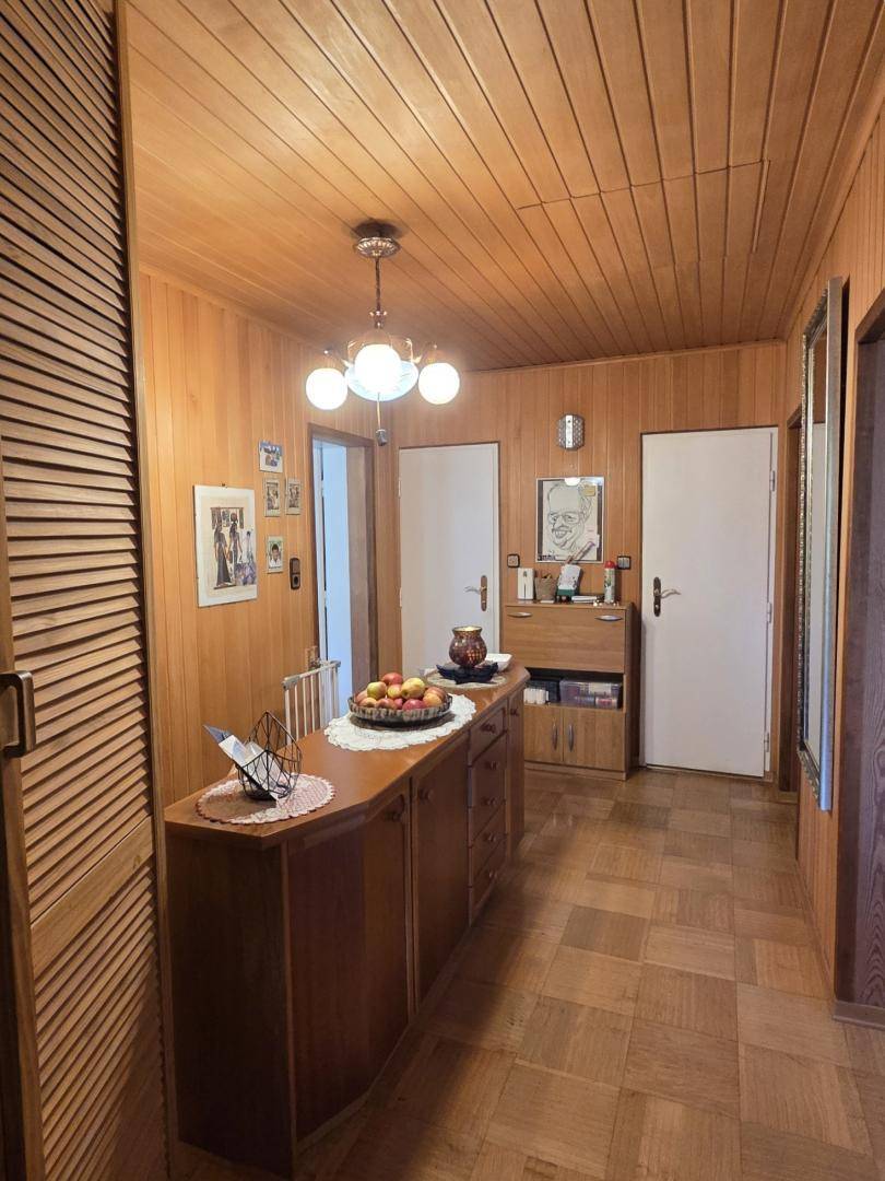 Gemütlicher Flur mit Holzvertäfelung, Parkettboden und traditionellen Möbeln.