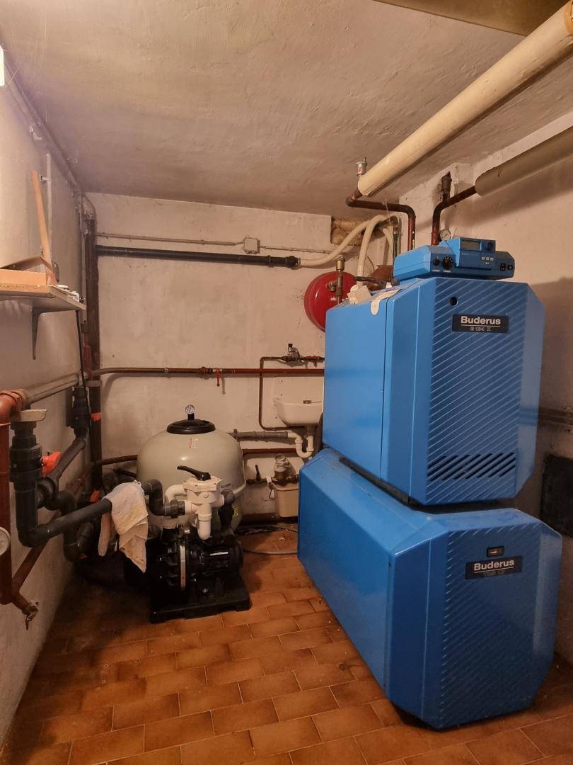 Heizungsraum im Keller mit moderner Buderus-Anlage und sichtbaren Rohren.